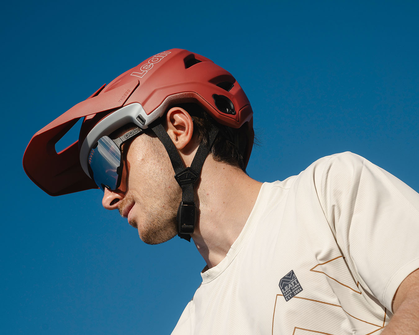Porträttbild på man med röd mountainbikehjälm från Leatt